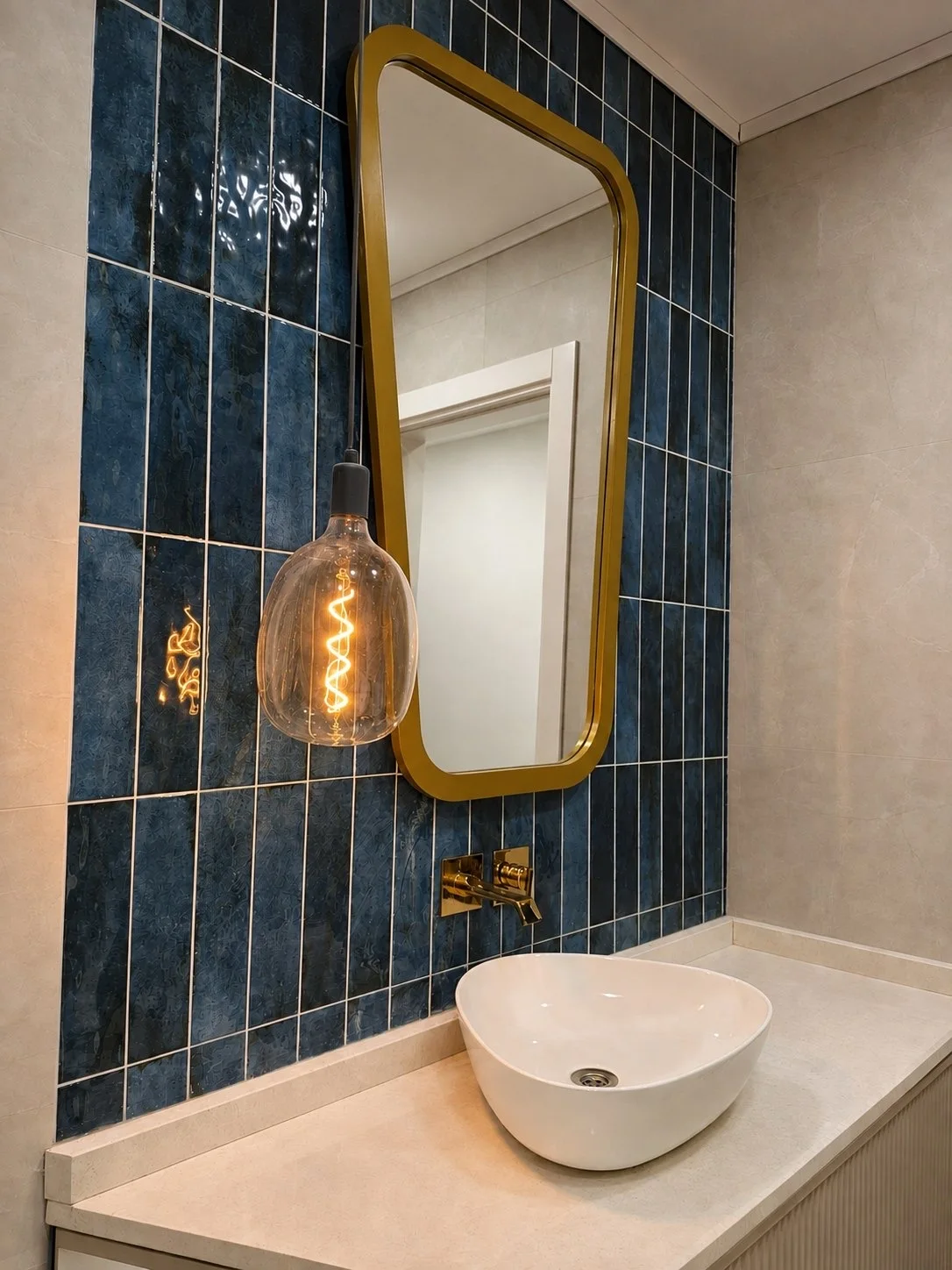 Projelerimiz Suadiye 3+1 Daire Yenileme: Banyo yenileme: lacivert karo duvar, altın çerçeveli ayna, sarkıt lamba ve tezgah üstü lavabo