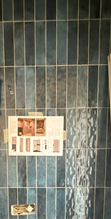 Duvara asılı 3D tasarım paftasına bakılarak yapılan lacivert karo uygulaması